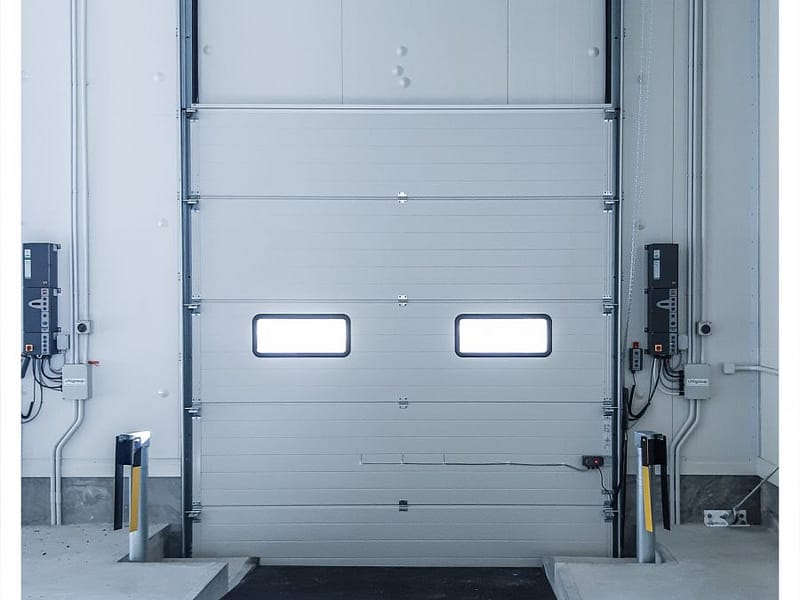 A sectional industrial door with vision panels at a loading dock.